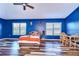 Bright bedroom with wood-look floors and a striking accent wall in a bold blue hue at 13181 Linzia Ln, Spring Hill, FL 34609