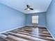 Simple bedroom with wood-look floors, a ceiling fan, and one window with coverings at 13181 Linzia Ln, Spring Hill, FL 34609