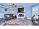 Comfortable living room featuring a fireplace, sleek ceiling fan, and wood-look floors at 13181 Linzia Ln, Spring Hill, FL 34609