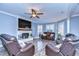 Cozy living room featuring a fireplace, ceiling fan, and comfortable leather seating at 13181 Linzia Ln, Spring Hill, FL 34609