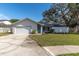 House exterior with a two-car garage and front yard at 1497 Rosetree Ct, Clearwater, FL 33764