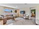 Open living area with neutral color palette, L-shaped sofa, and large window at 35188 Valley Ridge Rd, Dade City, FL 33525