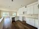 Bright kitchen with white cabinetry, quartz countertops, an island with sink, and hardwood floors at 5727 Desert Rose Pl, Tampa, FL 33615