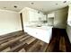 Spacious living room with hardwood floors leading into the kitchen area with white cabinetry and a quartz countertop at 5727 Desert Rose Pl, Tampa, FL 33615