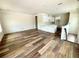 Spacious living room with hardwood floors leading into the kitchen area with white cabinetry and a quartz countertop at 5727 Desert Rose Pl, Tampa, FL 33615