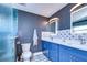Modern bathroom with blue vanity, double sinks, and glass shower at 13181 Linzia Ln, Spring Hill, FL 34609
