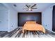 Bedroom with dark accent wall, ceiling fan, and wood-look flooring at 13181 Linzia Ln, Spring Hill, FL 34609