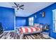 Blue bedroom with wood flooring, a bed with American flag bedding, and a ceiling fan at 13181 Linzia Ln, Spring Hill, FL 34609