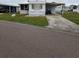 White single-wide mobile home with carport and small yard at 119 Saint Pierres Way, Apollo Beach, FL 33572