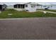 White mobile home with screened porch and small lawn at 119 Saint Pierres Way, Apollo Beach, FL 33572