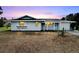 Light blue house with a white garage door and landscaped yard at 1201 Harkness Way, Sun City Center, FL 33573