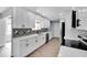 Renovated kitchen featuring white cabinets, black hardware, and stylish backsplash at 1201 Harkness Way, Sun City Center, FL 33573