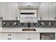 Close-up of the kitchen sink with a modern faucet and decorative tile backsplash at 1201 Harkness Way, Sun City Center, FL 33573
