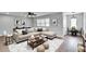 Bright living room boasts modern light fixture, gray walls, and plenty of seating at 1201 Harkness Way, Sun City Center, FL 33573