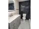 Modern bathroom with gray vanity, marble walls, and gold fixtures at 12506 Forest Hills Dr, Tampa, FL 33612