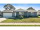 Newly renovated house featuring a gray brick facade, white garage door, and well-manicured lawn at 13150 94Th Ave N, Seminole, FL 33776