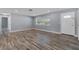 Living room with wood-look floors, neutral walls, and access to hallway at 13150 94Th Ave N, Seminole, FL 33776