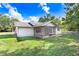 House with backyard, grassy lawn, and screened porch at 13209 Woodward Dr, Hudson, FL 34667