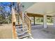 Wooden stairs leading up to the elevated home's deck at 39744 Amber Ave, Zephyrhills, FL 33540