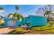 Light teal home with attached garage and tropical landscaping at 409 161St Ave, Redington Beach, FL 33708