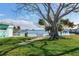 Relaxing patio area with seating under a large shade tree near waterfront at 409 161St Ave, Redington Beach, FL 33708