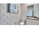 Stylish powder room with a granite countertop and starburst wallpaper at 4314 Pullet Ct, Lakewood Ranch, FL 34211