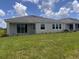 Backyard features a covered patio, a green lawn, and a view of the adjacent homes at 4314 Pullet Ct, Lakewood Ranch, FL 34211