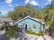 Cute teal home with palm trees and stone pathway at 605 E Spruce St, Tarpon Springs, FL 34689