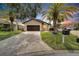 Charming single-story home features a well-manicured lawn, a private two-car garage, and mature palm trees at 6208 Spoonbill Dr, New Port Richey, FL 34652