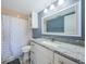 Updated bathroom with granite countertop, white cabinets, and patterned shower curtain at 6382 Palma Del Mar S Blvd # 123, St Petersburg, FL 33715