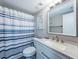 Clean bathroom, featuring a white vanity, blue striped shower curtain, and granite countertop at 6382 Palma Del Mar S Blvd # 123, St Petersburg, FL 33715