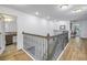 Bright second floor hallway with decorative metal railing and nearby bathroom entrance at 8272 Artisan Way, Seminole, FL 33777