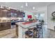 Kitchen with a granite island with seating that connects to the dining area with stainless steel appliances at 8272 Artisan Way, Seminole, FL 33777