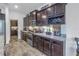 Kitchen features dark wood cabinetry, granite countertops, stainless steel appliances, and ample storage at 8272 Artisan Way, Seminole, FL 33777