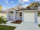 Newly built home with light blue exterior, landscaping, and driveway at 8306 N Marks St, Tampa, FL 33604