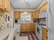 Condo kitchen with light wood cabinets and view to living room at 1814 Mariner Dr # 159, Tarpon Springs, FL 34689