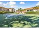 Outdoor tennis court with green surface and surrounding landscaping at 1814 Mariner Dr # 159, Tarpon Springs, FL 34689