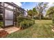 Landscaped backyard with lush greenery and a screened enclosure at 5006 Ruby Flats Dr, Wimauma, FL 33598