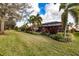 Landscaped backyard with a path leading to the pool area at 5006 Ruby Flats Dr, Wimauma, FL 33598