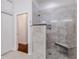 Large walk-in shower with stone tile and bench at 5006 Ruby Flats Dr, Wimauma, FL 33598