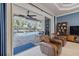 Gathering room with leather armchairs and sliding glass doors leading to the pool area at 5006 Ruby Flats Dr, Wimauma, FL 33598