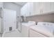 Bright laundry room with white cabinets, washer, and dryer at 5006 Ruby Flats Dr, Wimauma, FL 33598