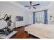 Main bedroom with dark hardwood floors, and a TV at 5006 Ruby Flats Dr, Wimauma, FL 33598