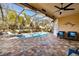 Covered patio with comfortable seating overlooking the pool at 5006 Ruby Flats Dr, Wimauma, FL 33598