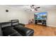 Living room with hardwood floors, large TV, and sectional sofa at 6006 Soaring Ave, Temple Terrace, FL 33617