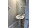 A small bathroom featuring a pedestal sink, large mirror and modern hardware at 6232 Bayside Key Dr, Tampa, FL 33615
