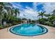 Community pool featuring a pool house, metal fencing, and palm trees at 6232 Bayside Key Dr, Tampa, FL 33615