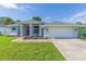 Single-story home with gray exterior, two-car garage, and well-maintained landscaping at 10328 Henderson St, Spring Hill, FL 34608