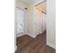 Home hallway featuring wood-look floors, a door to an exterior area, and access to a bathroom at 10328 Henderson St, Spring Hill, FL 34608