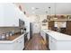 White kitchen with an island, stainless steel appliances, and wood flooring at 10328 Henderson St, Spring Hill, FL 34608